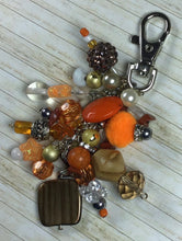 Load image into Gallery viewer, Autumn Glow Purse Charm featuring a mix of orange, gold, and brown beads, wooden accents, sparkling crystals, and a silver lobster clasp, designed for handbags, keychains, or backpacks.