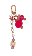 Keychain with pink pom-pom, heart-shaped charm, and coral decorations on a white background