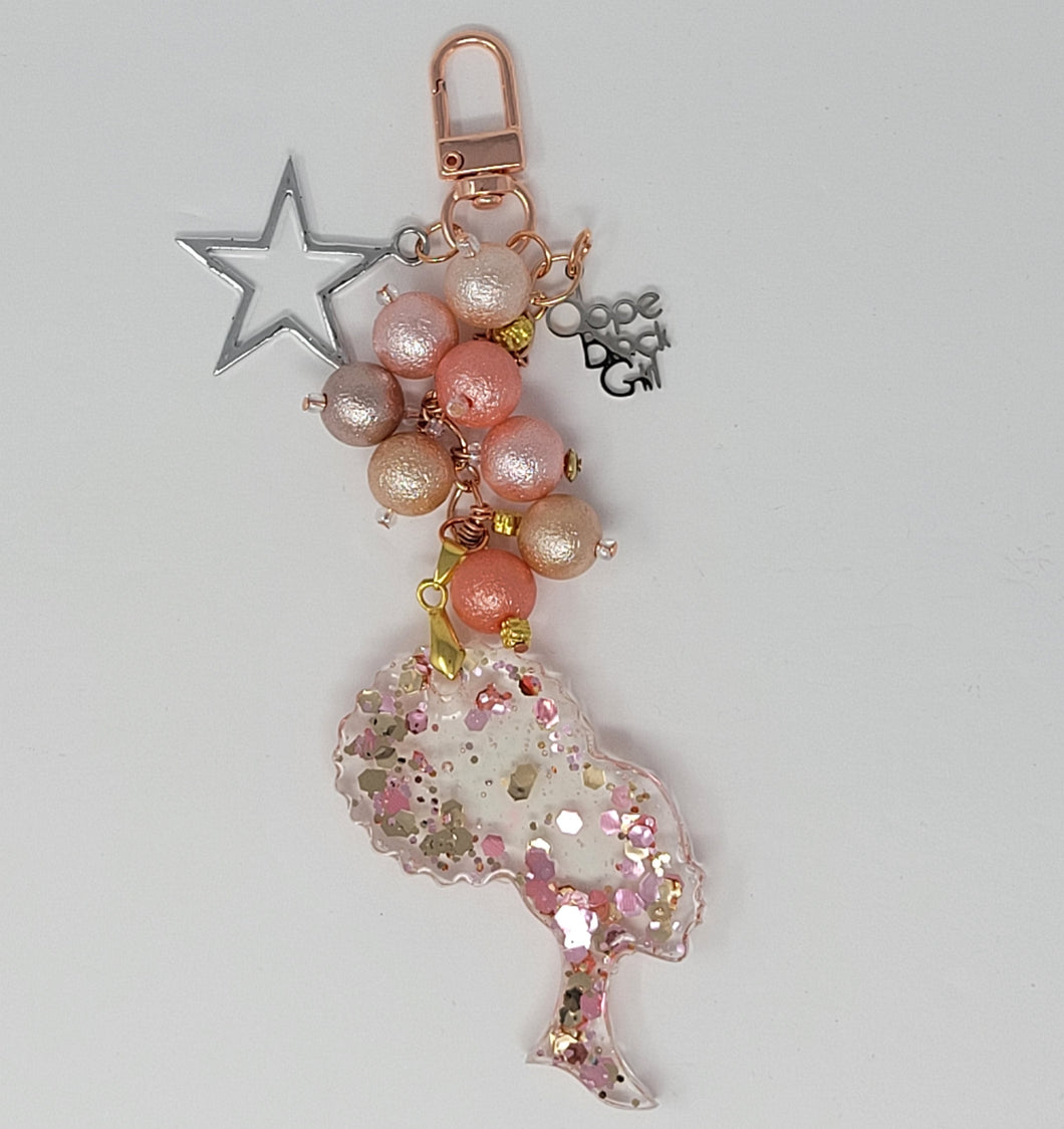 Dope Black Girl Glam purse charm by Bougie Girl Boutique, featuring a sparkling pink and rose gold theme, resin afro silhouette, pink and rose gold beads, a silver star, and a 'Dope Black Girl' charm.