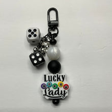 Load image into Gallery viewer, A beaded keychain charm featuring two black dice, a white faux-pearl bead, black and white beads, and a white acrylic charm with the text 'Lucky Lady' and colorful bingo balls, attached to a black carabiner clip.